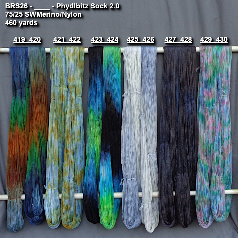 Picture of hand-dyed yarns drying on a rod.