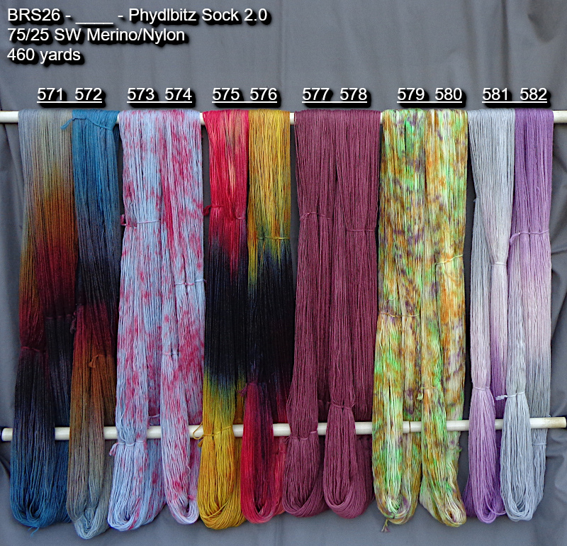 Picture of hand-dyed yarns in many colors, drying on a rack outdoors.