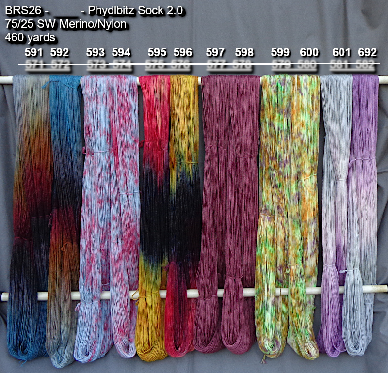 Picture of hand-dyed yarns in many colors, drying on a rack outdoors.