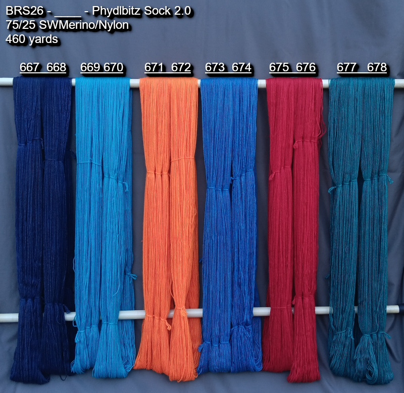 Picture of hand-dyes yarns in many colors, drying on a rack.