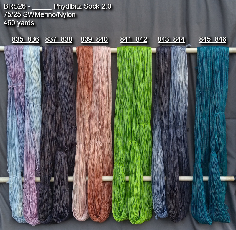 Picture of hand-dyed yarns in many colors, hanging on rack to dry.